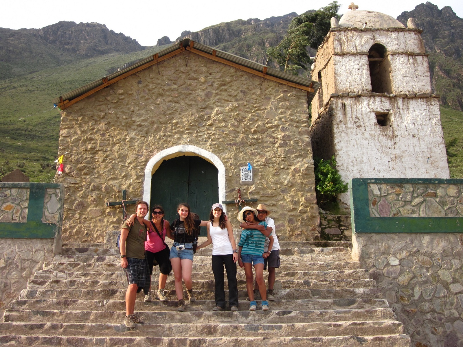 Tour group standing on steps in front of historic church, Peru