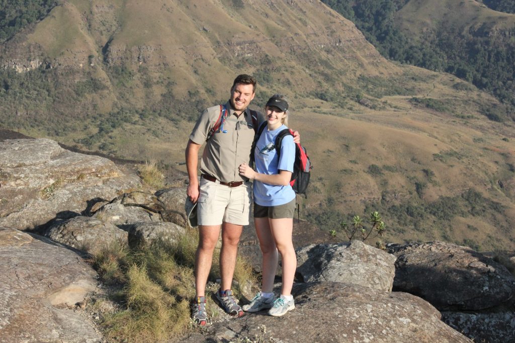 Man & woman standing on mountain in South Africa